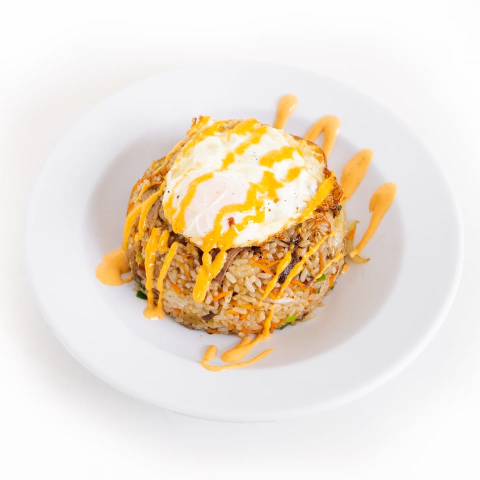 GoPho's Vietnamese fried rice with vegetables, topped with a fried egg and orange sauce.